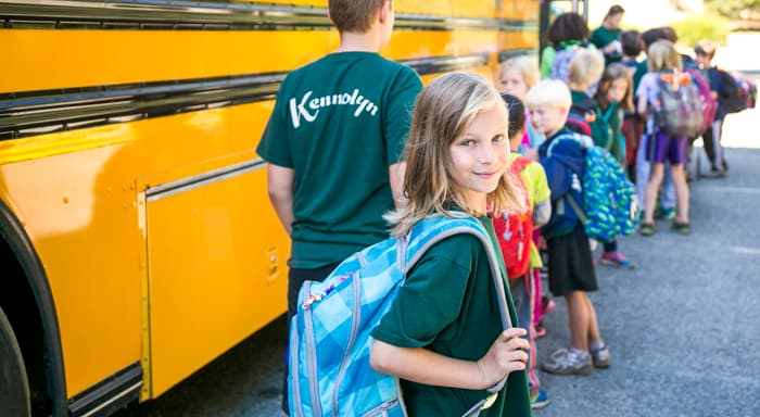 A camper looks at the camera while in line for the bus